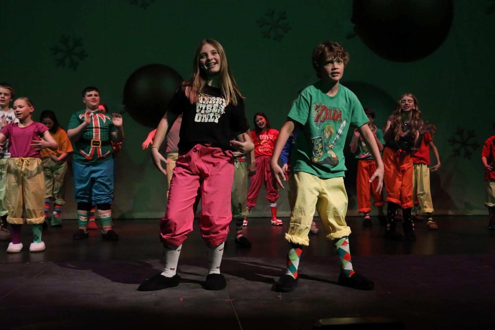 Young people gather in front of an ornament drop.